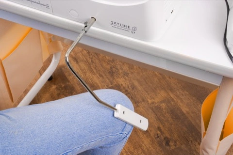 Close-up of the Janome Skyline S7 ergonomic hands-free knee lift lever accessory serving Wilmington and Coastal NC.