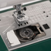 • Close-up of the Janome Travel Mate 200 automatic thread trimmer and top drop-in jam-proof bobbin serving Clayton, Garner, and Angier, NC.