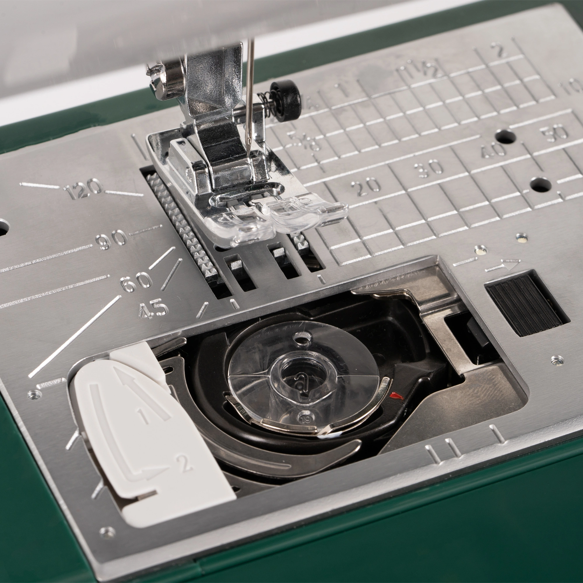 • Close-up of the Janome Travel Mate 200 automatic thread trimmer and top drop-in jam-proof bobbin serving Clayton, Garner, and Angier, NC.